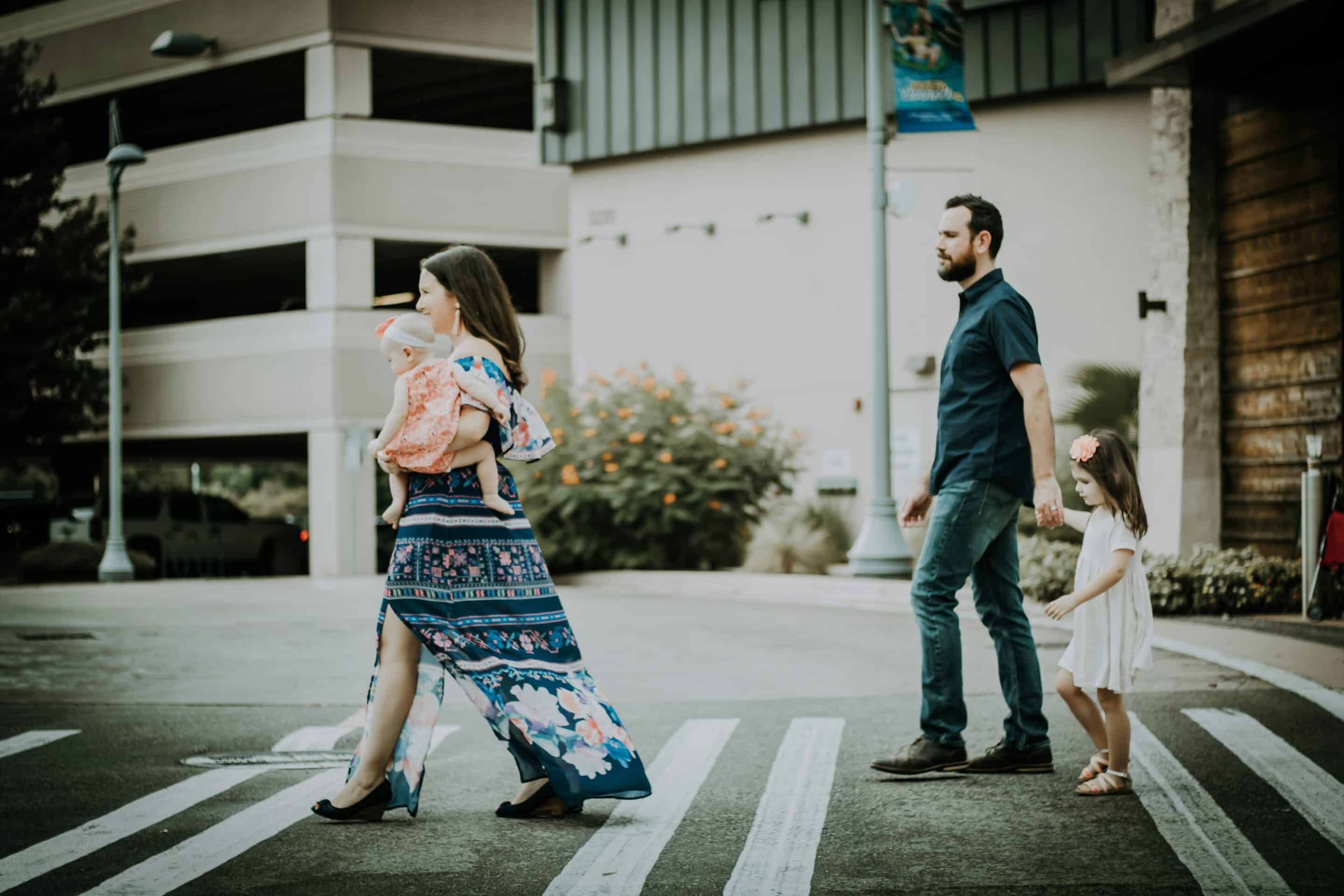 Family crossing street in urban setting.