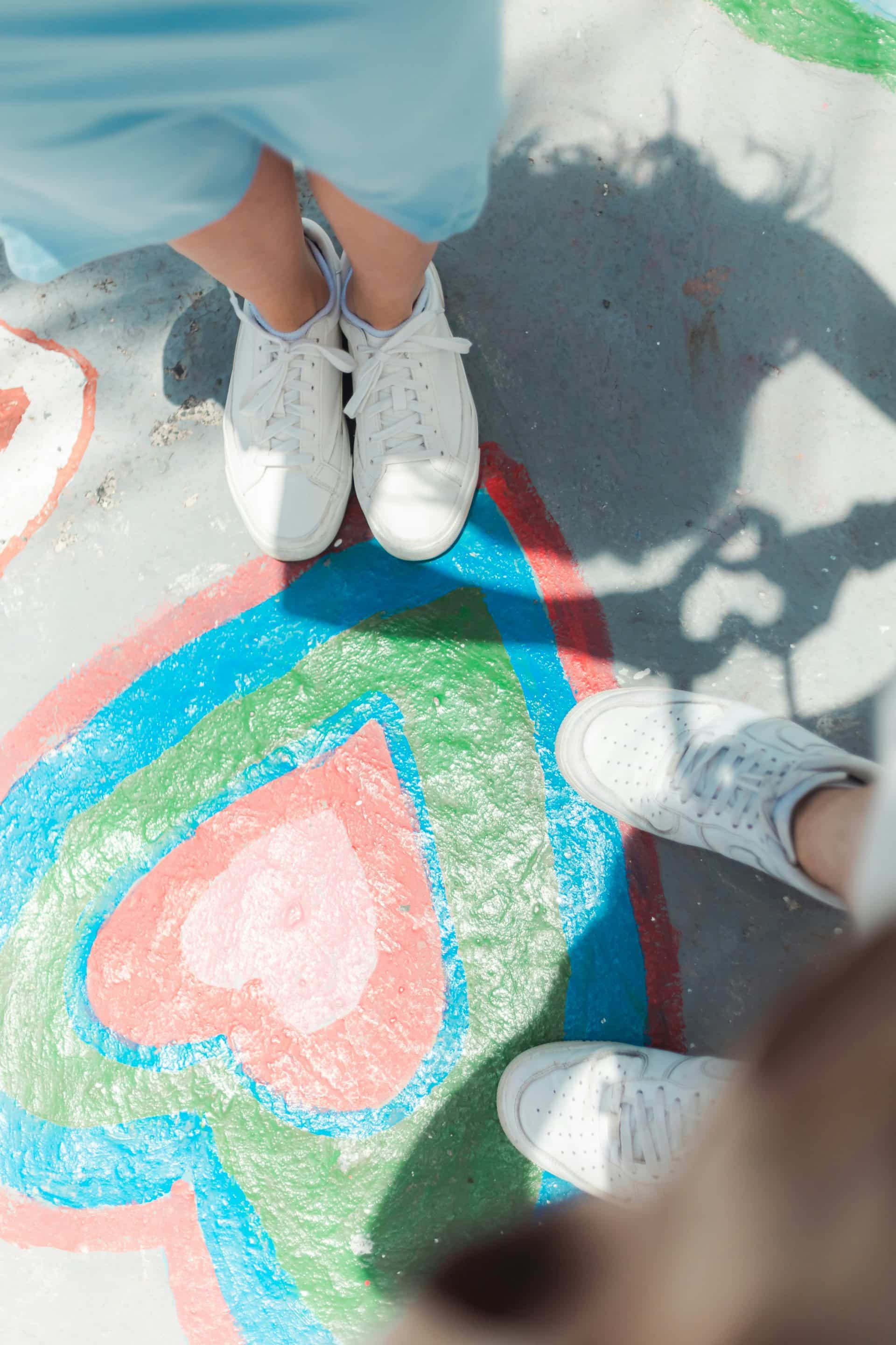 Two people standing on colorful pavement art.